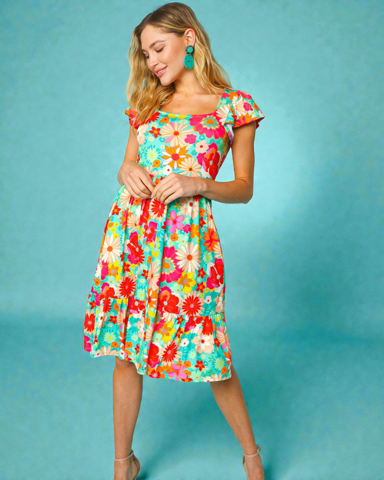 Woman wearing a colorful floral dress against a blue background