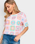 Camiseta de manga corta con estampado de flores en color verde azulado y naranja en color avena