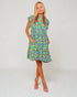 Woman wearing a colorful floral dress on a white background