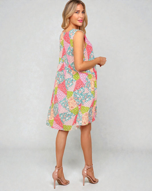 Woman wearing a colorful floral dress on a plain background