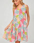 Woman wearing a colorful floral dress on a plain background