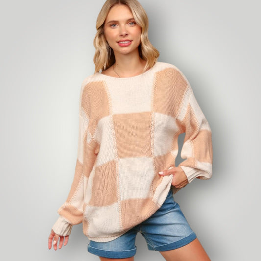 Woman wearing a checkered sweater and denim shorts on a plain background