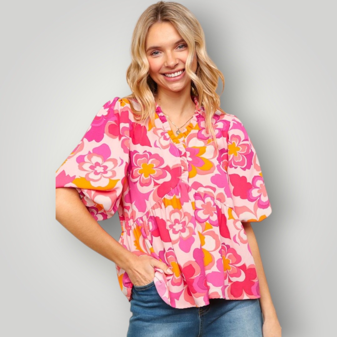 Woman wearing a pink floral blouse against a gray background