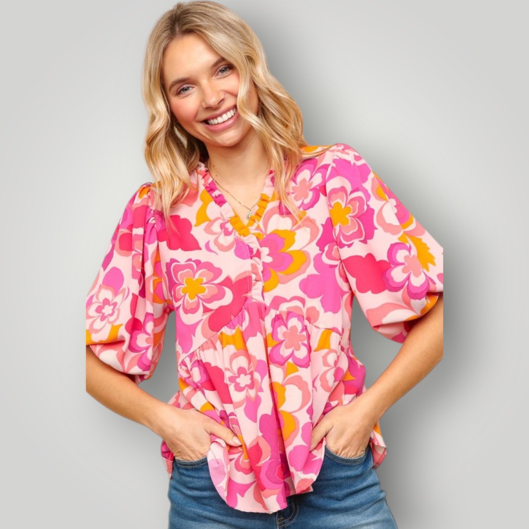 Woman wearing a pink floral blouse against a gray background