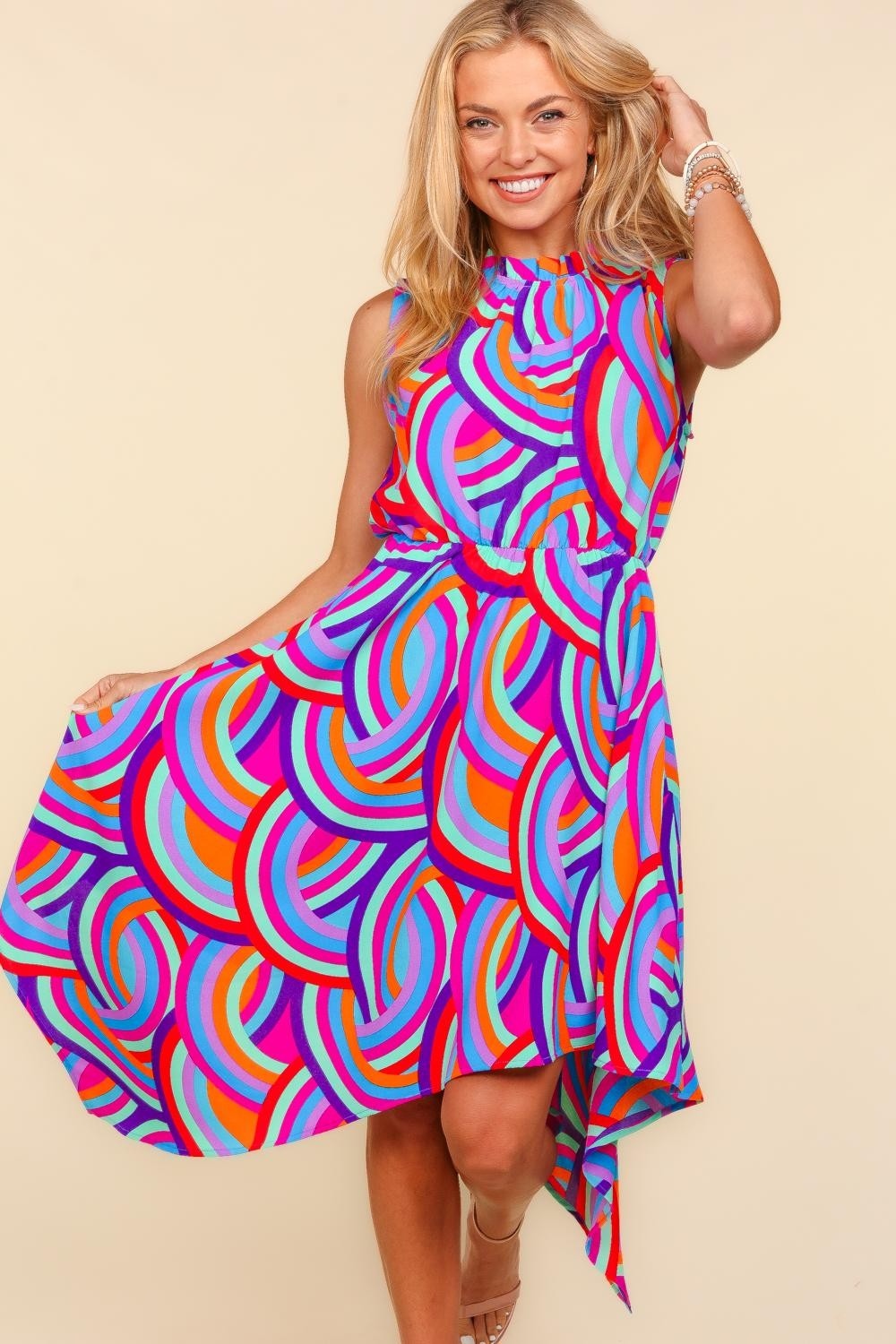 Woman wearing a colorful dress with a swirl pattern on a beige background