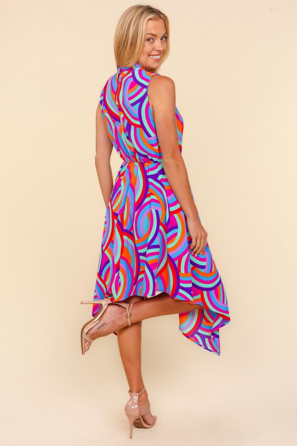 Woman wearing a colorful dress with a pattern on a beige background