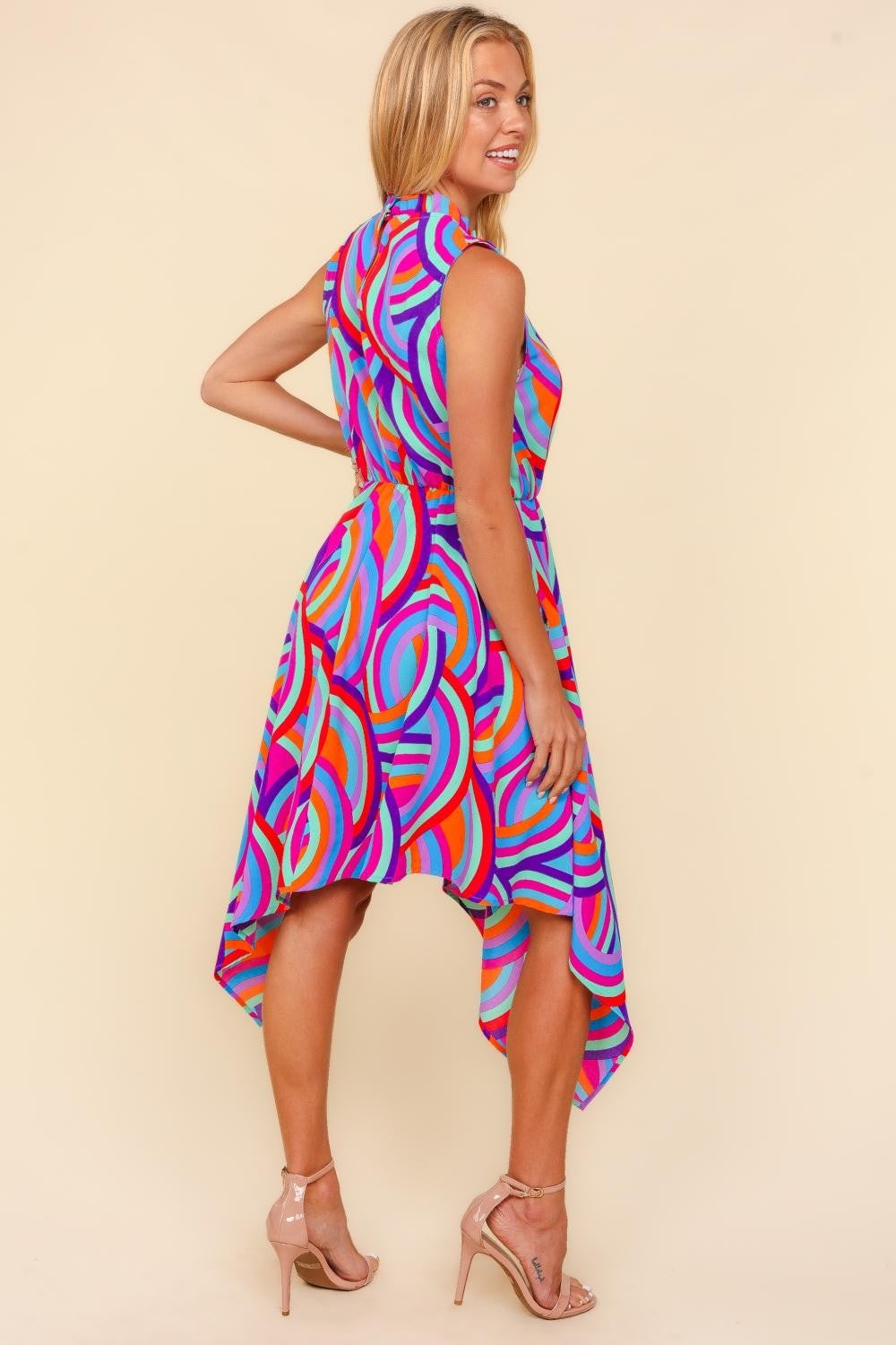 Woman wearing a colorful dress with a pattern on a beige background