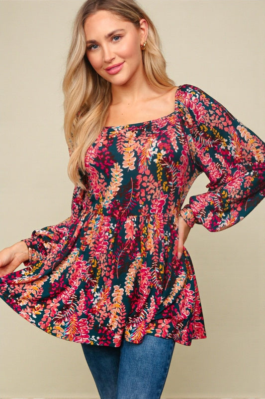 Woman wearing a colorful floral blouse with long sleeves on a beige background