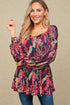Woman wearing a colorful floral dress against a beige background