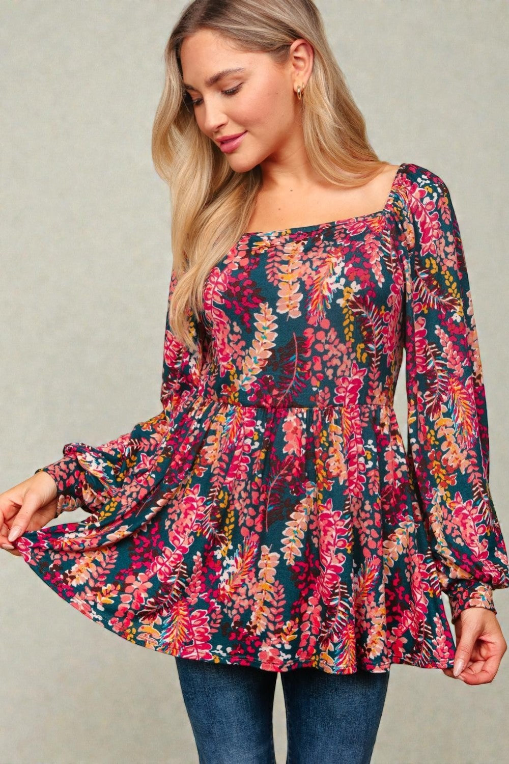 Woman wearing a colorful floral dress against a neutral background