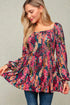 Woman wearing a colorful floral dress against a neutral background