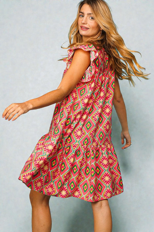 Woman wearing a pink patterned dress against a light gray background