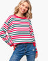 A woman wearing a long-sleeve crewneck sweater with horizontal red, green, and white stripes, paired with blue jeans, against a plain white background.