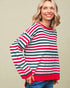 Woman wearing a red, green, and white striped sweater against a beige background