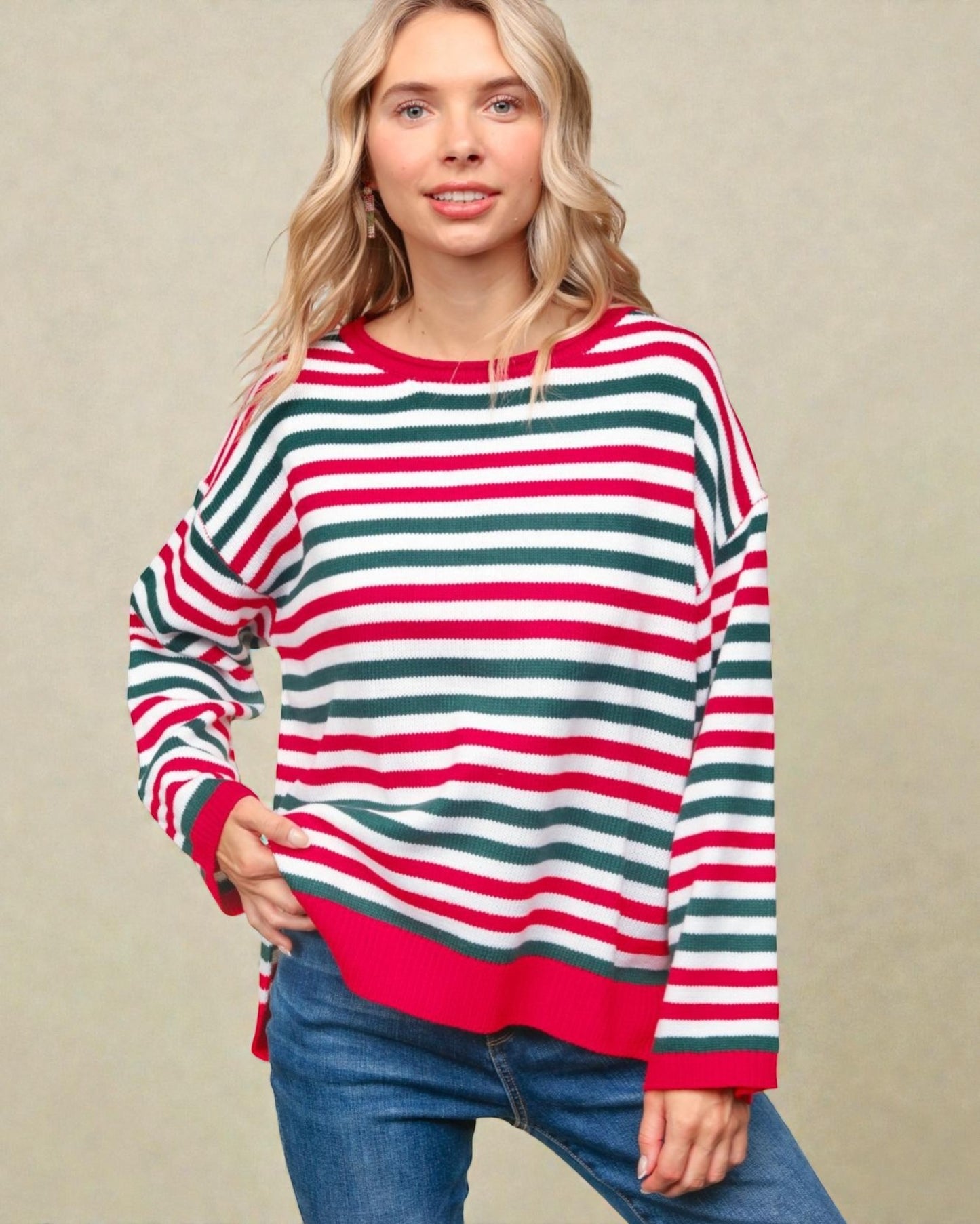 Woman wearing a red, green, and white striped sweater against a beige background