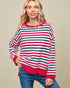 Woman wearing a red, green, and white striped sweater against a beige background