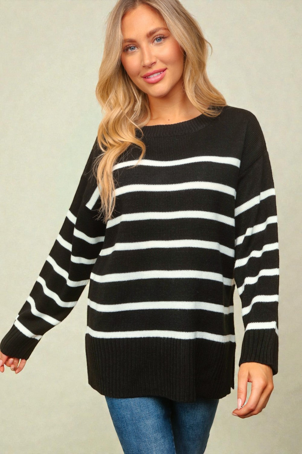Woman wearing a black and white striped sweater against a plain background