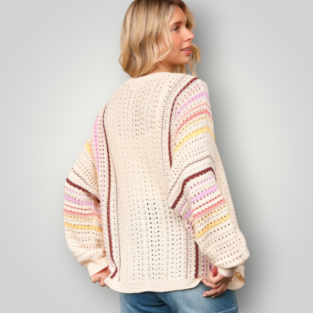 Woman wearing a colorful striped sweater against a plain background