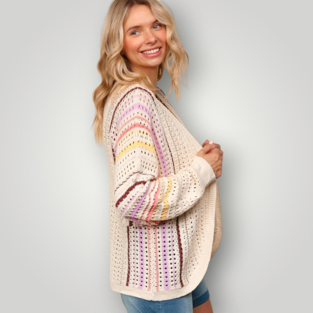 Woman wearing a colorful striped sweater against a plain background
