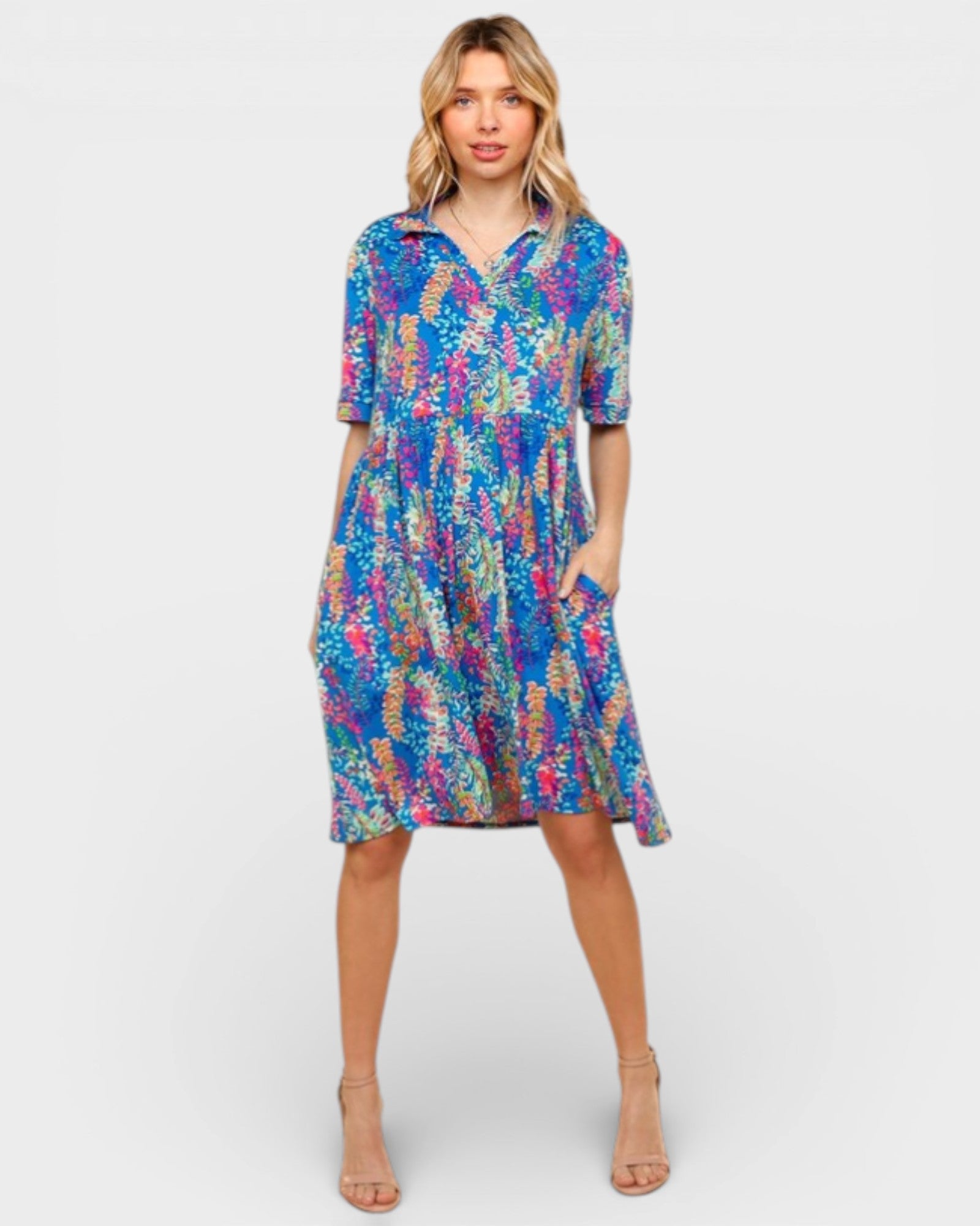 Woman wearing a colorful patterned dress on a white background