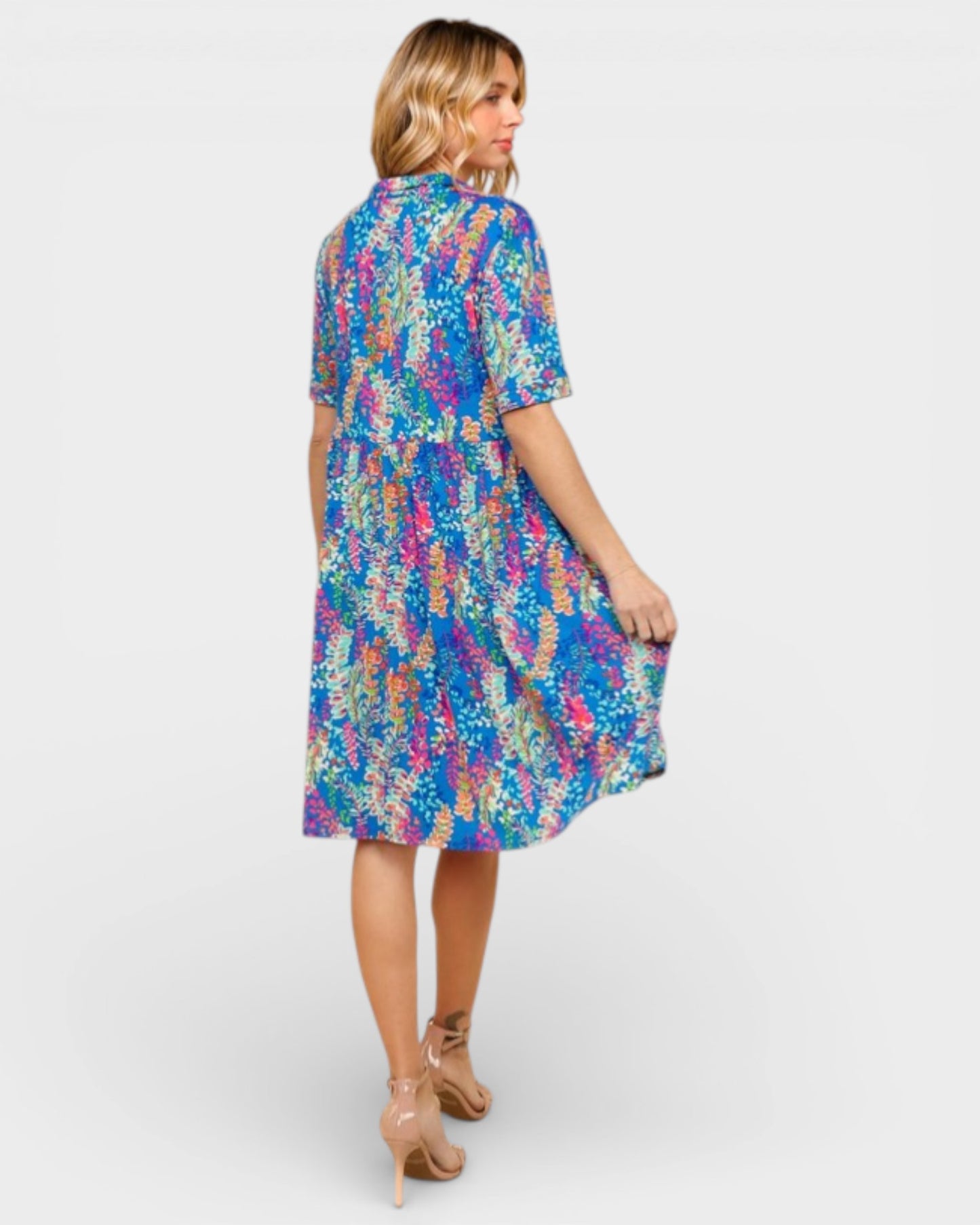 Woman wearing a colorful patterned dress on a white background