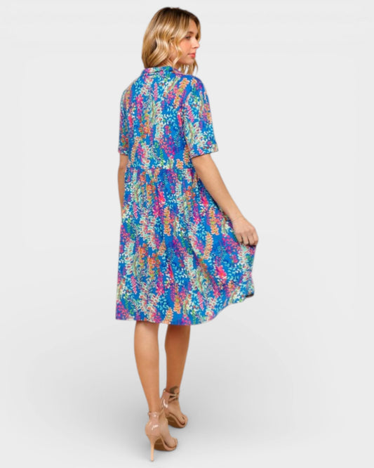 Woman wearing a colorful patterned dress on a white background