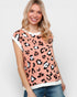 Woman wearing a pink leopard print top with white trim on a plain background