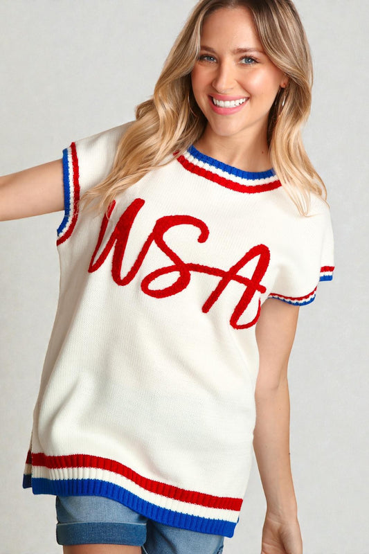 Woman wearing a white sleeveless sweater with red and blue accents and 'USA' text.