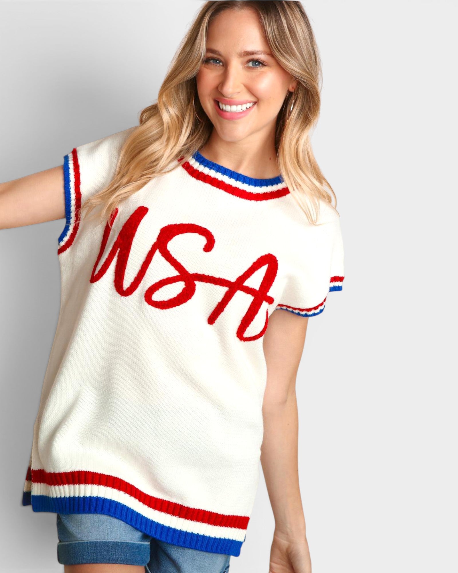 Woman wearing a white sleeveless top with 'USA' printed in red on a plain background