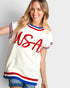 Woman wearing a white sleeveless top with 'USA' printed in red on a plain background
