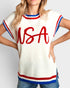 Person wearing a white sweater with 'USA' printed in red on a plain background