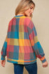 Woman wearing a colorful plaid sweater against a beige background