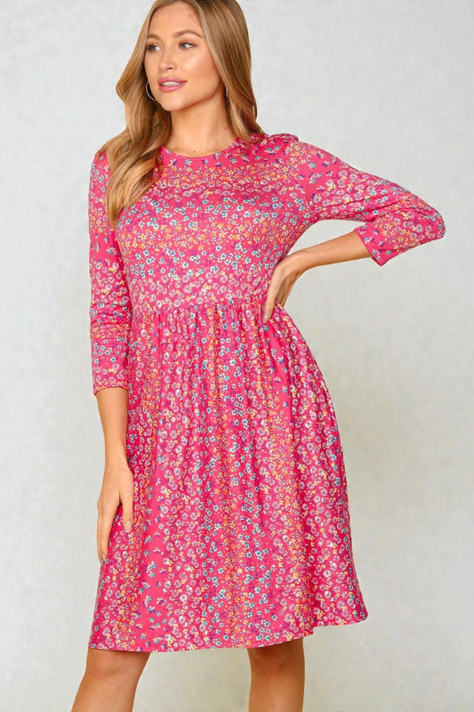 Woman wearing a pink floral dress against a plain background