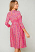 Woman wearing a pink floral dress against a plain background