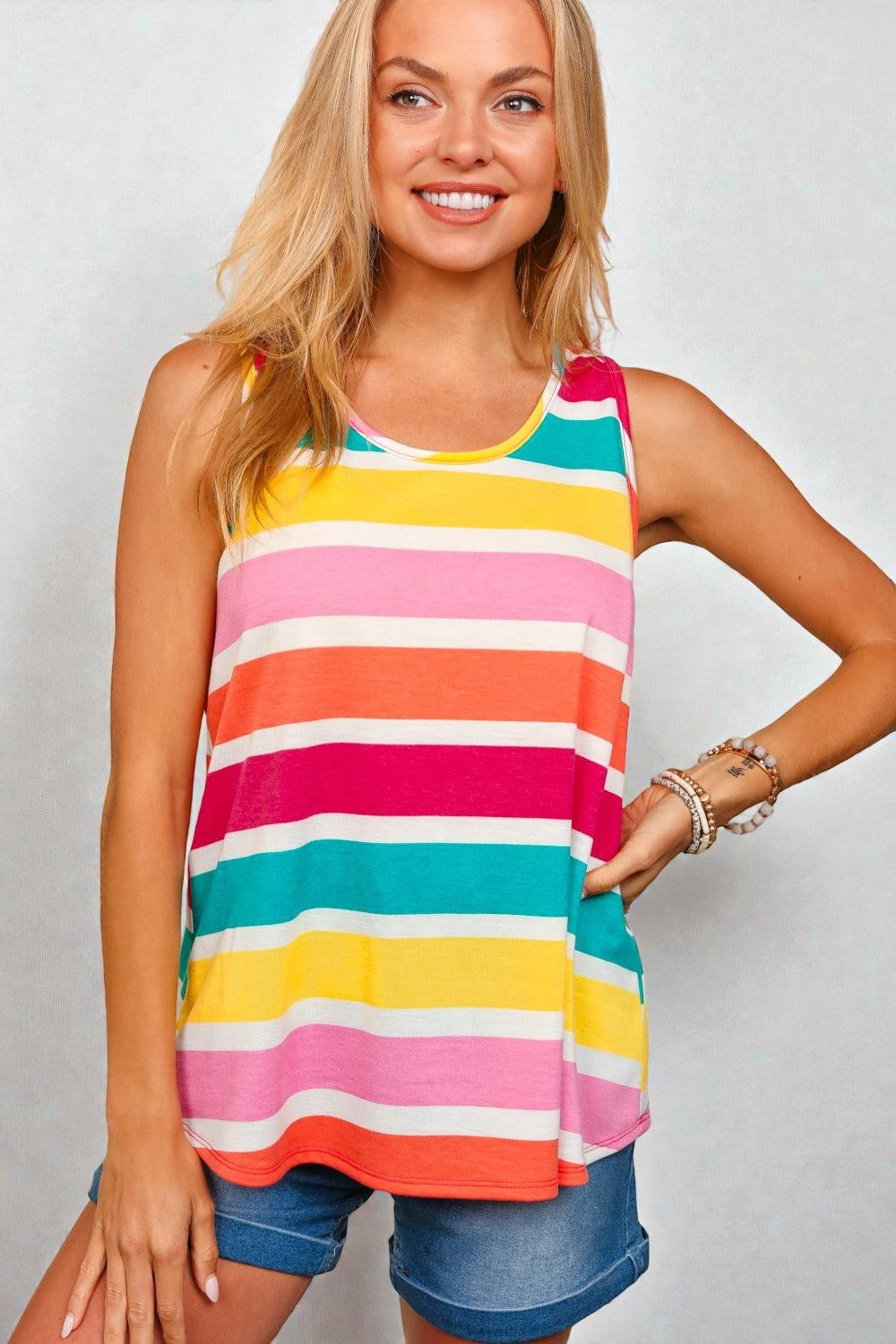 Woman wearing a colorful striped tank top against a plain background