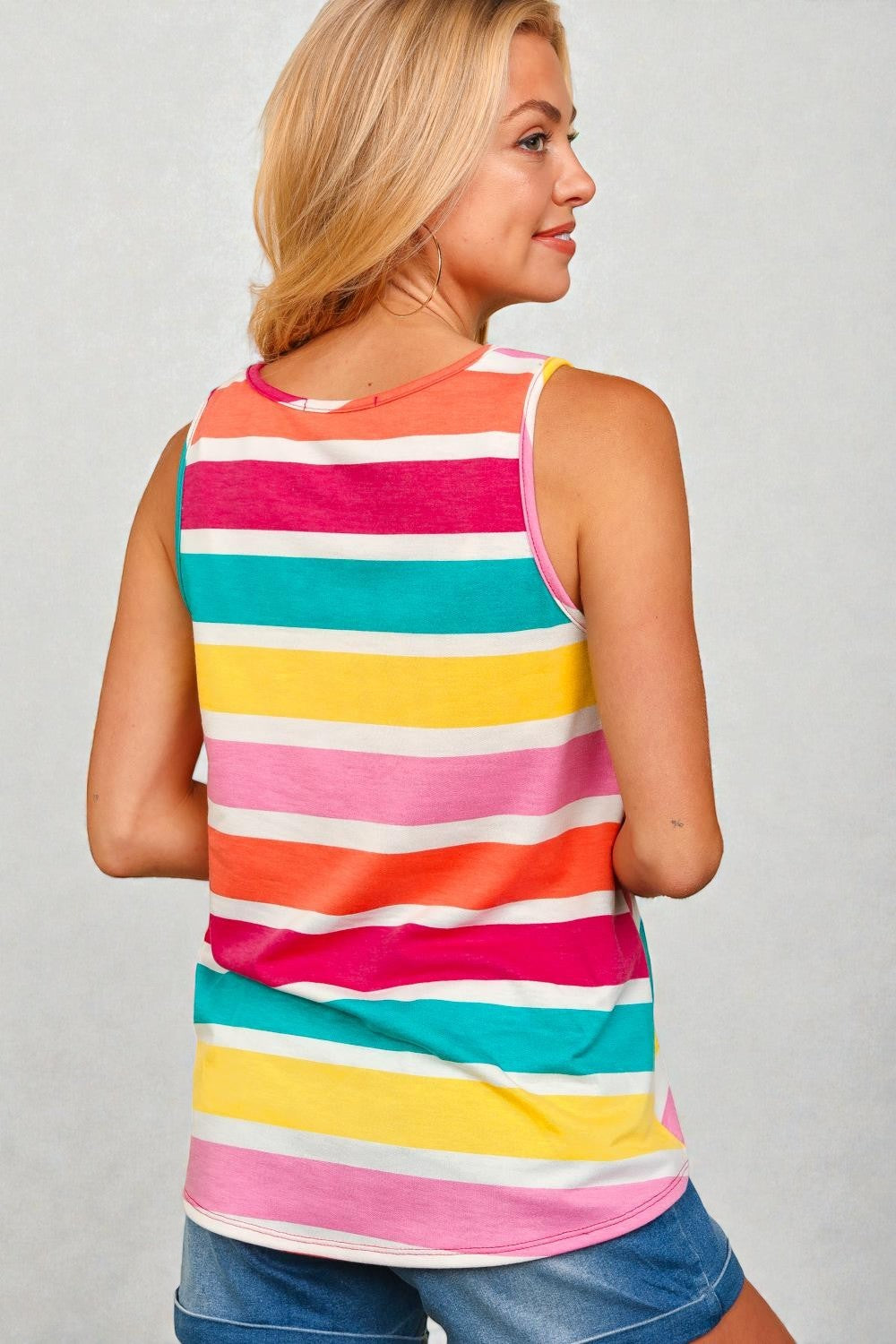 Woman wearing a colorful striped tank top against a plain background