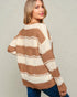Woman wearing a brown and white striped sweater against a plain background