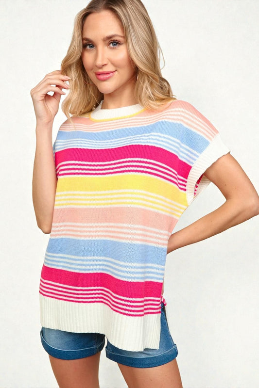 Woman wearing a colorful striped sweater and denim shorts on a white background