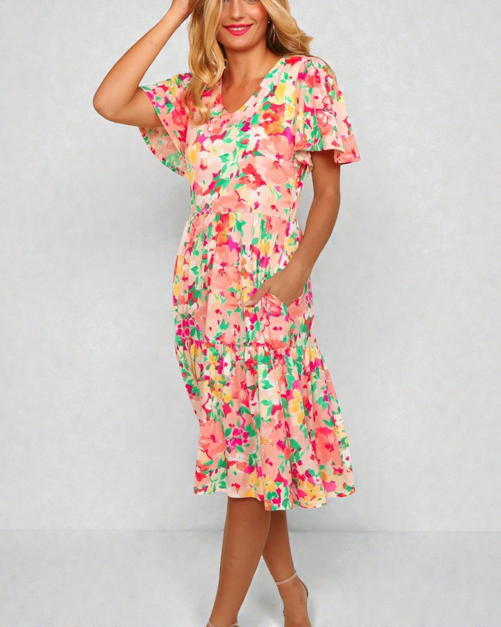 Woman wearing a colorful floral dress on a plain background