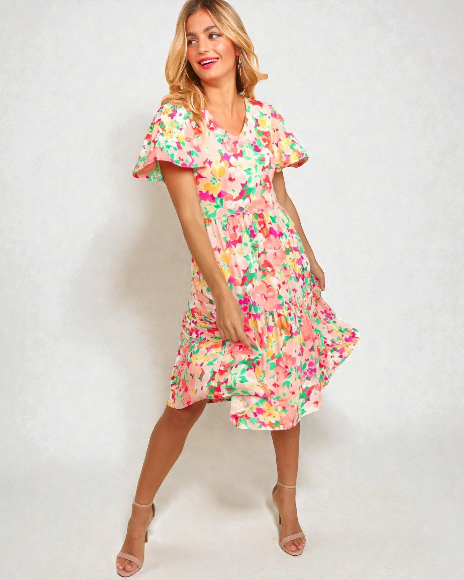 Woman wearing a colorful floral dress on a white background