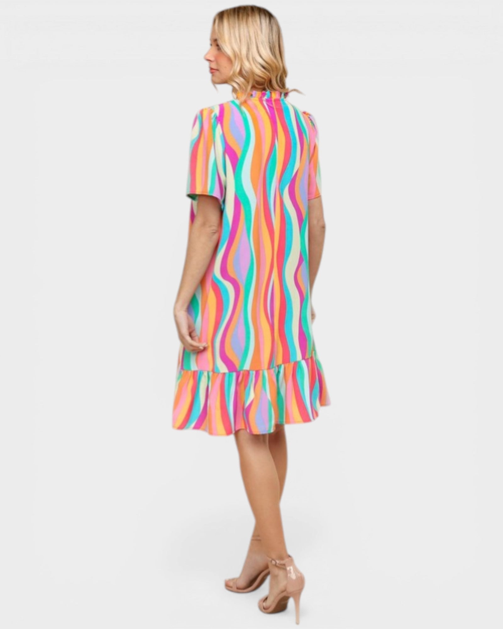 Woman wearing a colorful striped dress on a white background
