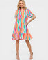 Woman wearing a colorful striped dress on a white background