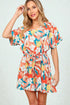 Woman wearing a colorful floral romper on a white background