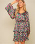Woman wearing a colorful floral dress against a beige background