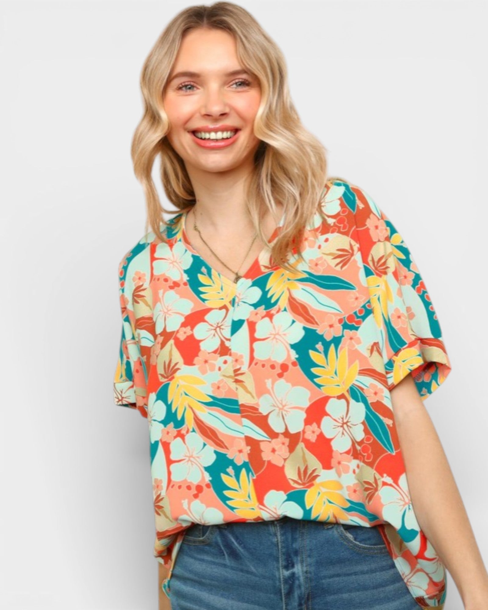 Woman wearing a colorful floral blouse against a white background