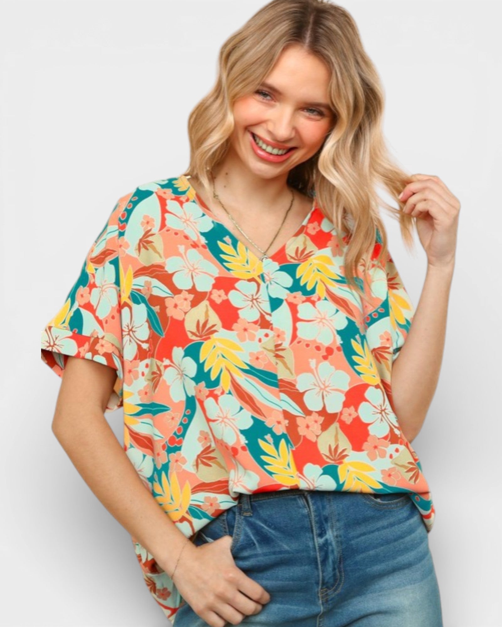 Woman wearing a colorful floral blouse against a white background