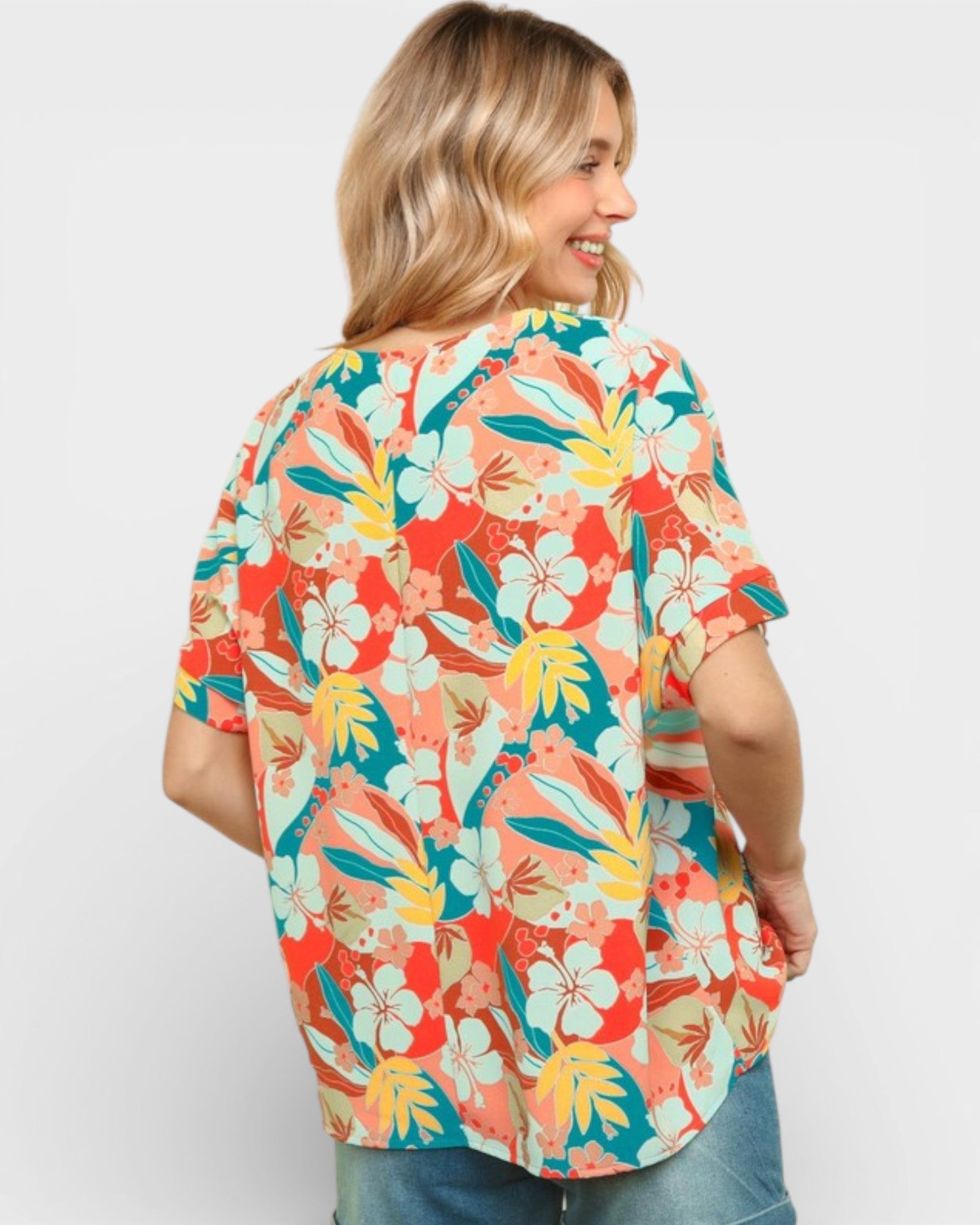 Woman wearing a colorful floral shirt against a white background