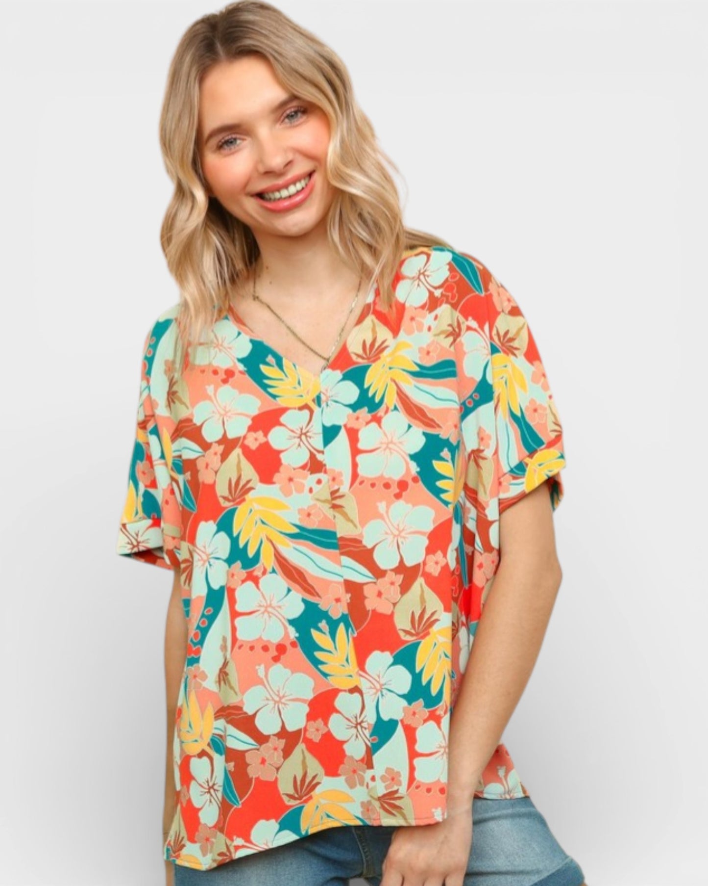 Woman wearing a colorful floral blouse against a white background