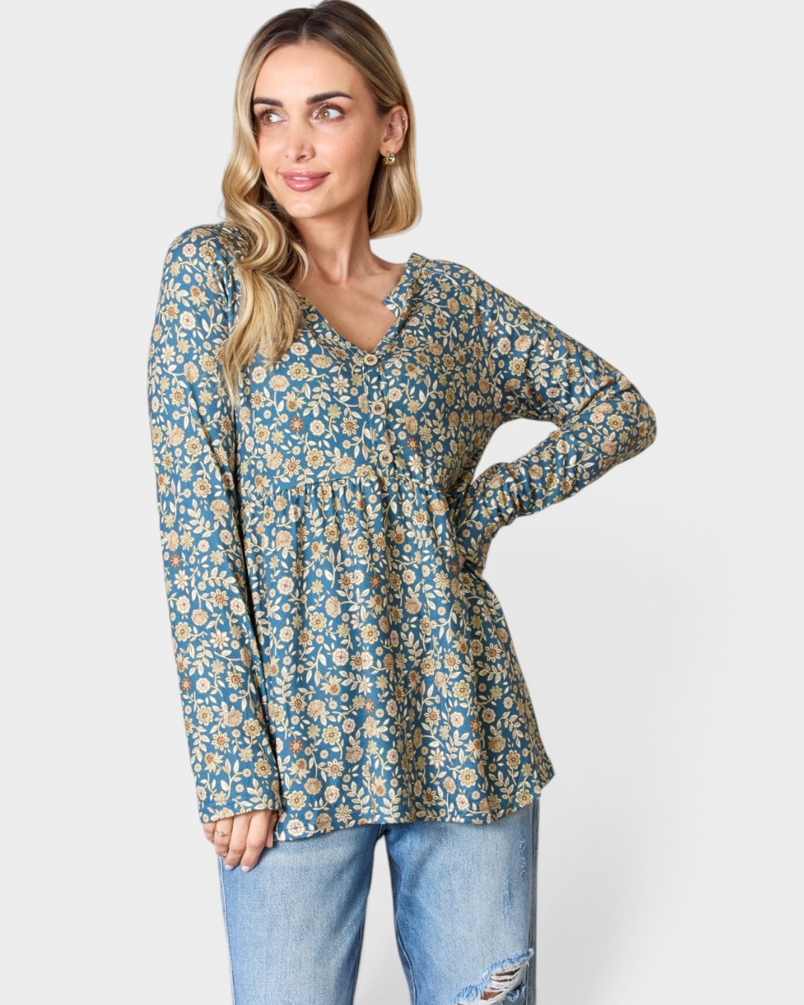 Woman wearing a floral blouse and jeans on a white background