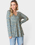 Woman wearing a floral blouse and jeans on a white background